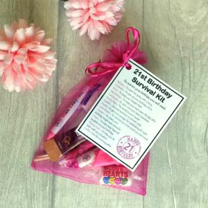 Pink 21st birthday survival kit in organza bag with laminated label explaining each item's symbolic meaning