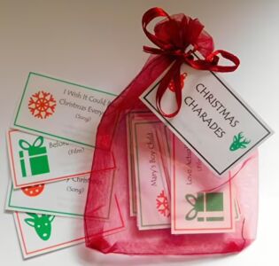 Handmade Christmas charade game with 23 laminated cards in organza bag featuring Christmas films and songs for family parties